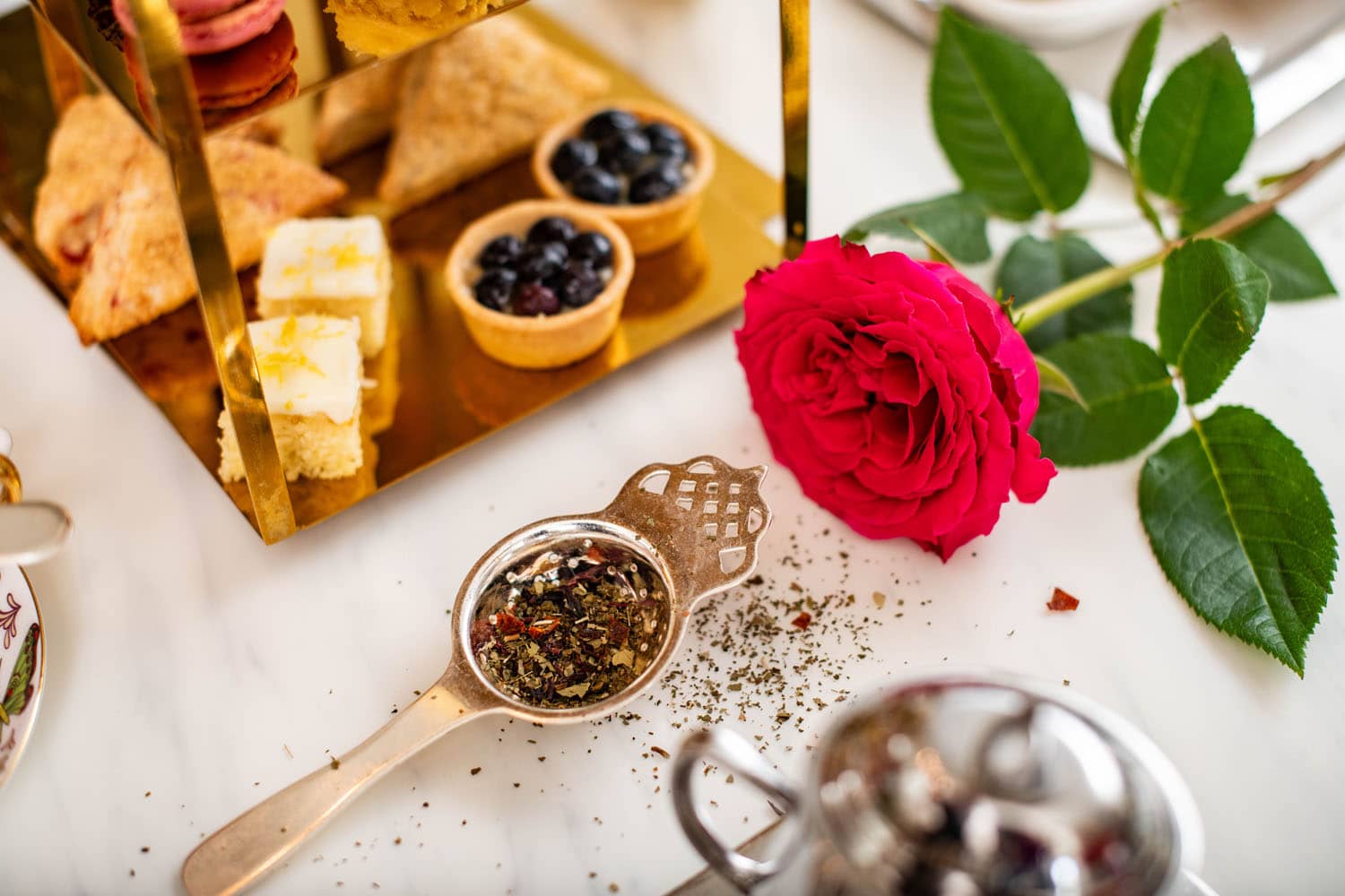A plated assortment of tea and small plates on a table inside The Raleigh Room restaurant