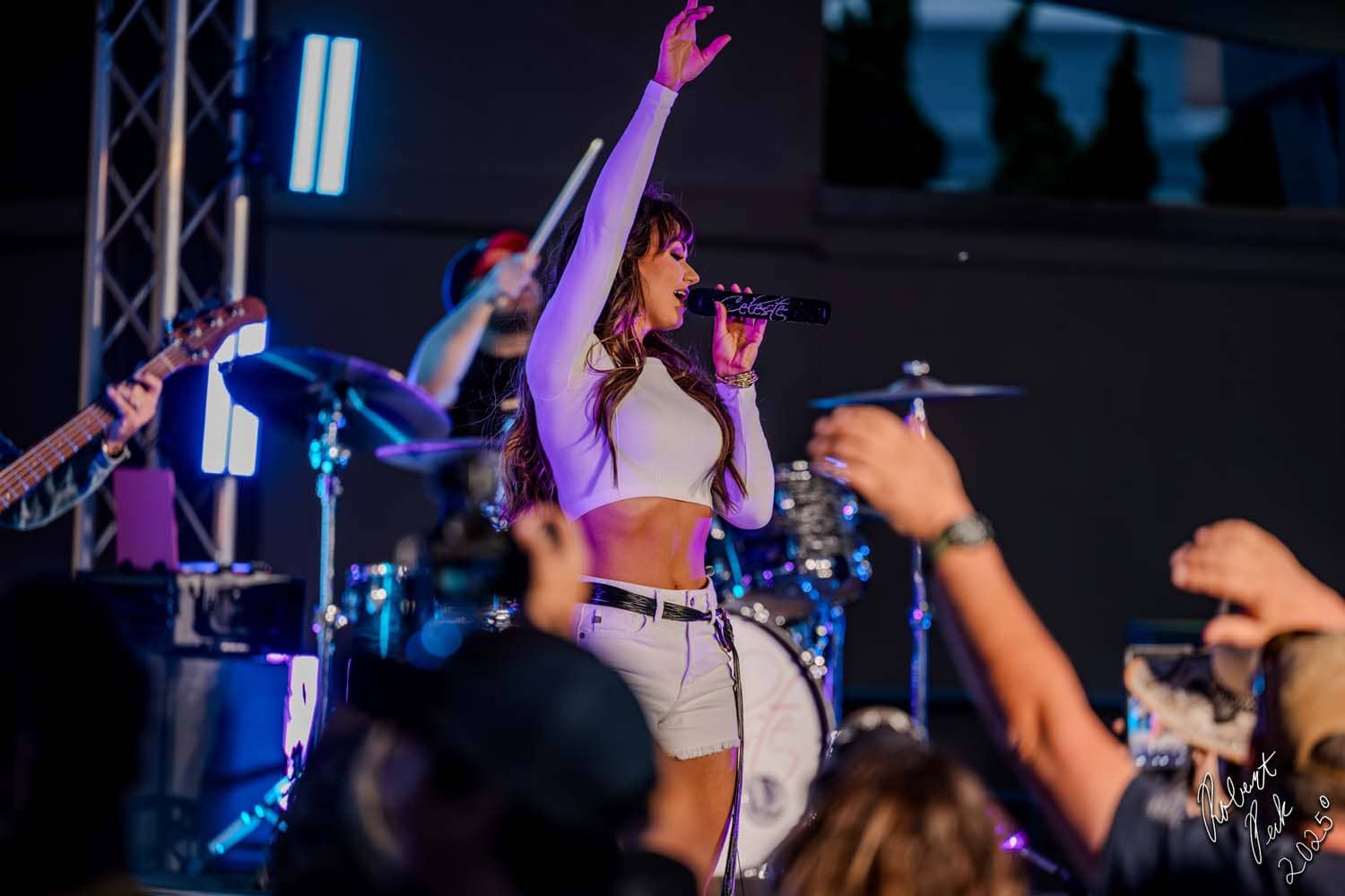 Artist Celest Kellogg performing live music on stage at a concert