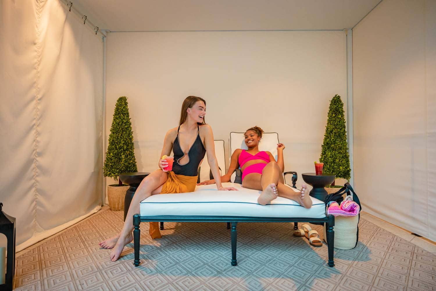 Two women sitting in cabana's at The Historic Cavalier Hotel indoor pool