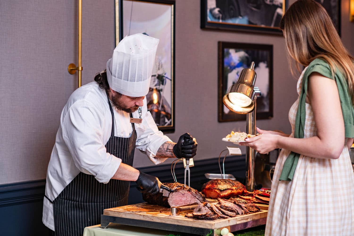 A chef carving meats on a table during a holiday brunch at The Historic Cavalier Hotel