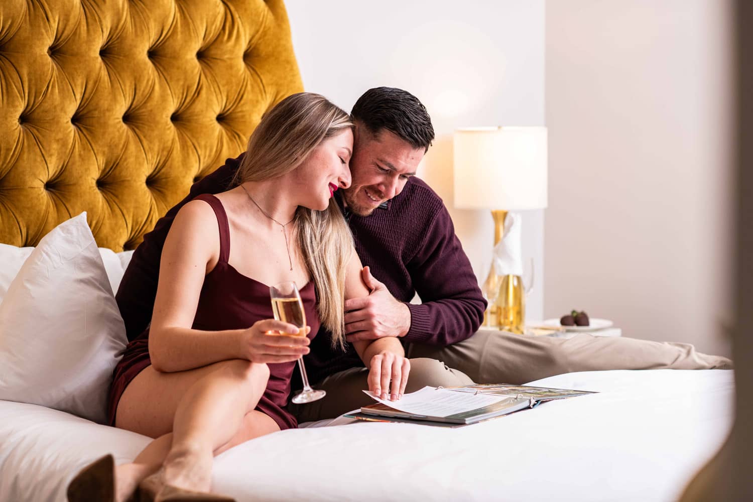 A couple browsing an in-room amenity menu at The Historic Cavalier Hotel