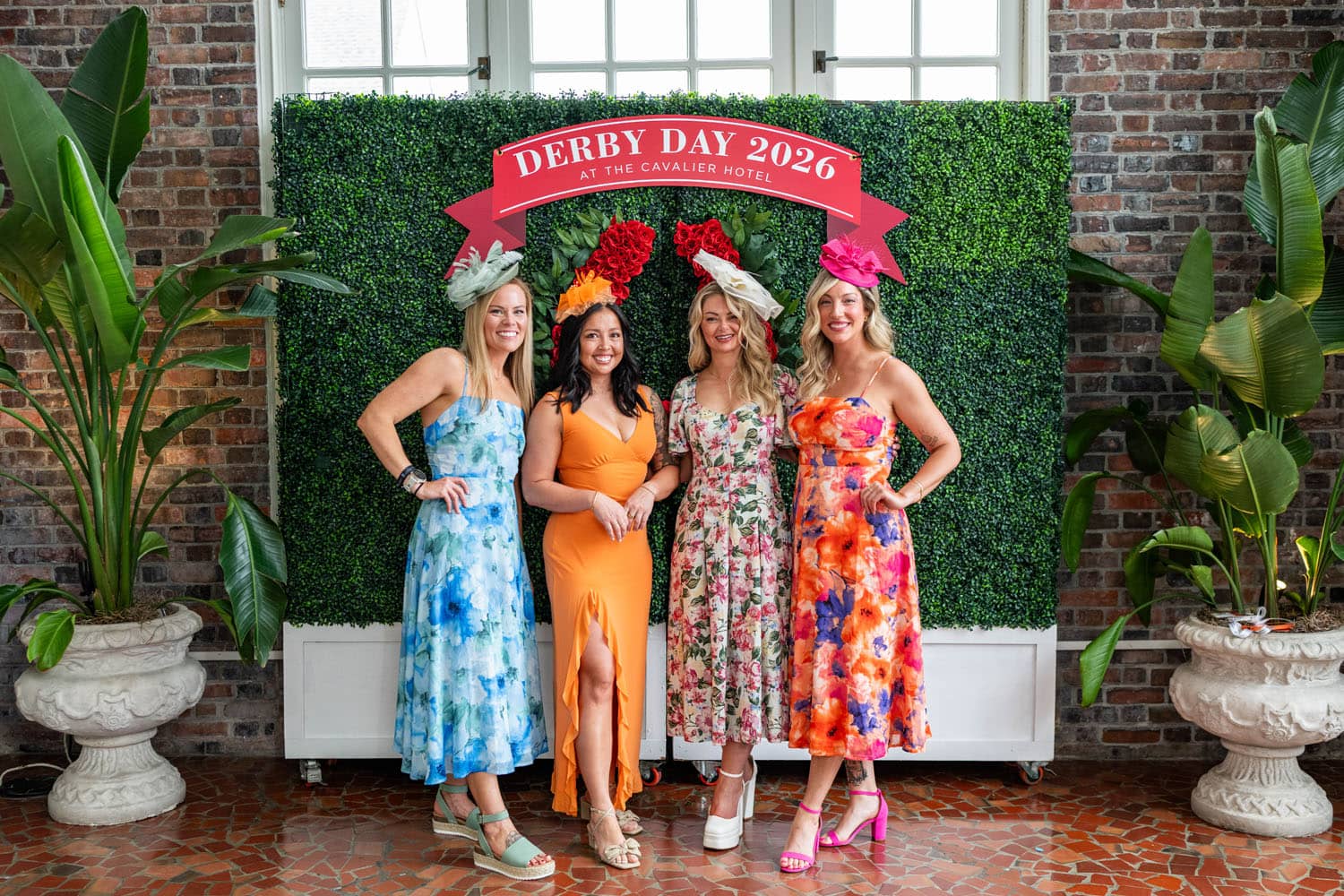 Four women posing for a photo at a Kentucky Derby event