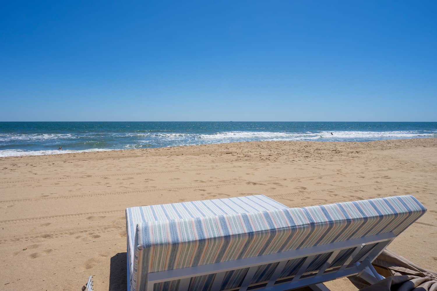 An empty beach cabana and ocean waves on a sunny day