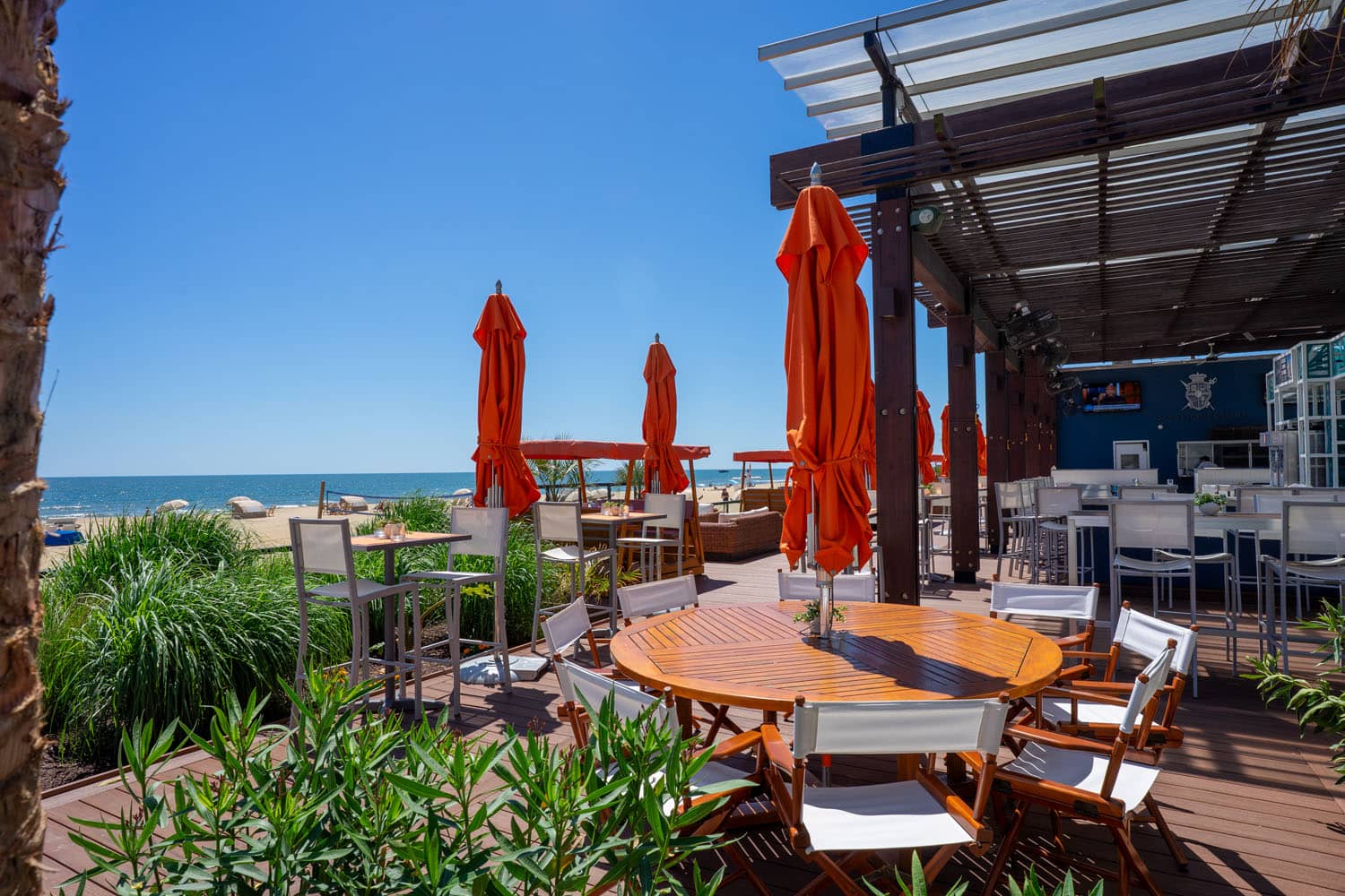 A beachside view of the seating area at The Deck Seagrill & Bar
