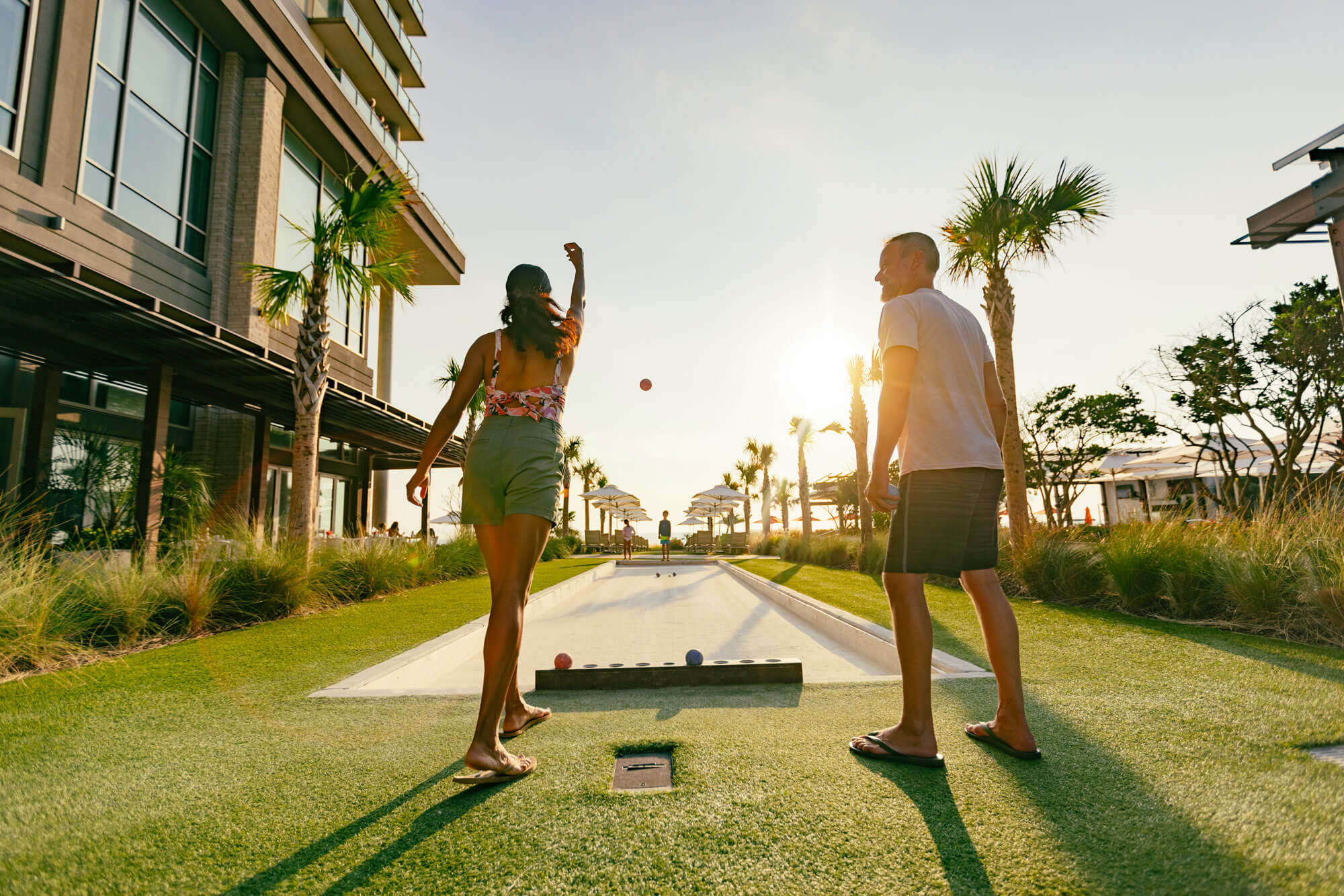 Couple playing bocce on the lawn outside of the Marriott Virginia Beach Oceanfront Resort